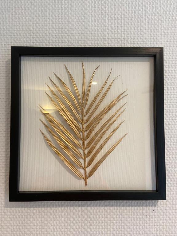 une image encadrée d’une feuille de palme sur un mur dans l'établissement appart 8 -les moulins, à Cherbourg en Cotentin