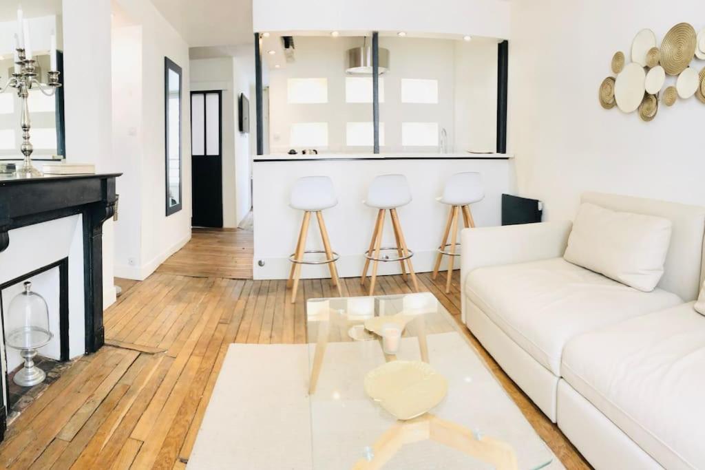 un salon avec un canapé blanc et une table dans l'établissement Nid douillet Gare du Nord Montmartre Barbès, à Paris