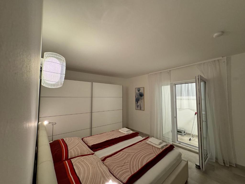 a bedroom with a bed and a large window at Apartments Villach in Villach