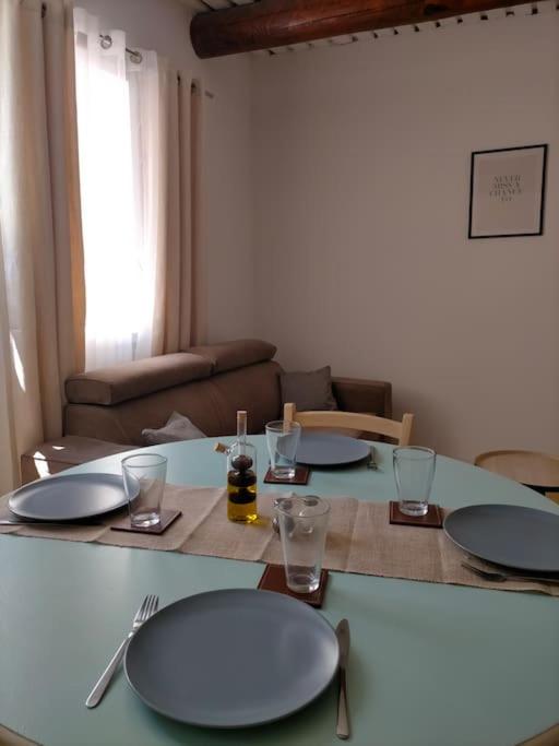une table avec des assiettes et des verres au-dessus dans l'établissement Appartement centre-ville Orange, à Orange