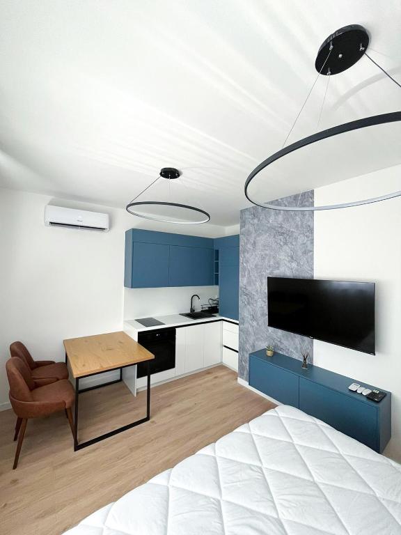 a bedroom with a bed and a table and a kitchen at Apartman Skyroom in Banja Luka