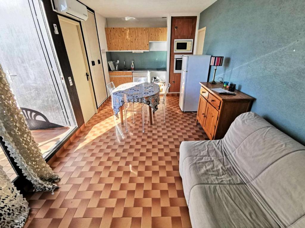Il comprend une cuisine équipée d'un canapé, d'une table et d'un réfrigérateur. dans l'établissement Résidence MARYSABLE - 2 Pièces pour 4 Personnes 774, à Port-Leucate