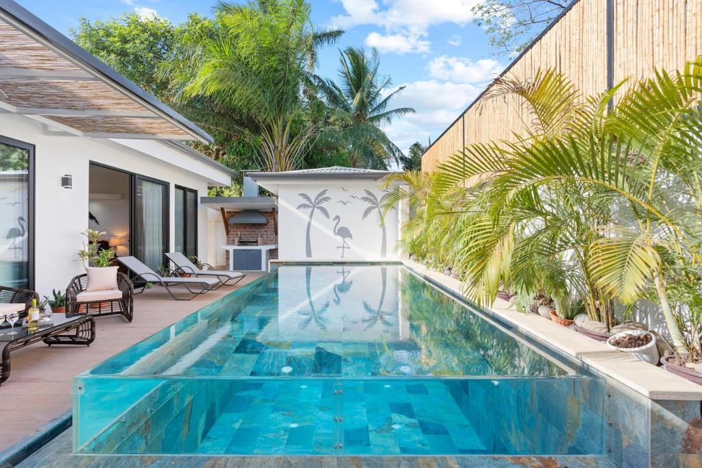 a swimming pool in the middle of a house at Swim-Through Glass Pool Villa, 5min Beach in Playa Flamingo