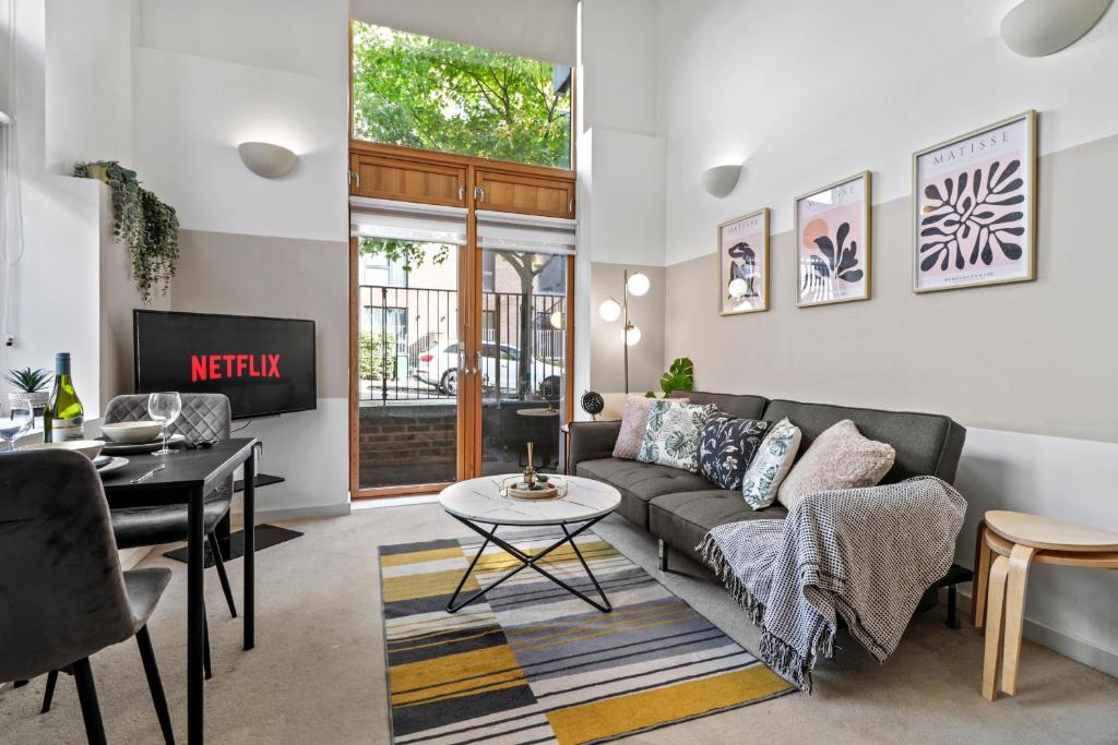 a living room with a couch and a table at Sleek Modern City Apartment in Milton Keynes