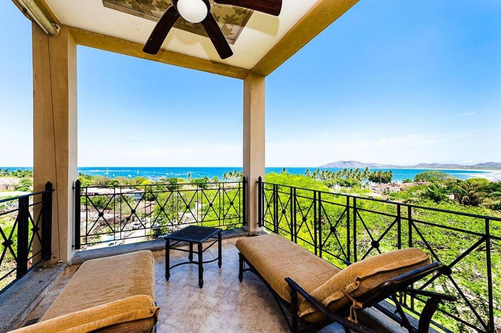 a balcony with a couch and a view of the ocean at Swim-Up Pool Bar, Walk to Beach & Panoramic Views in Tamarindo
