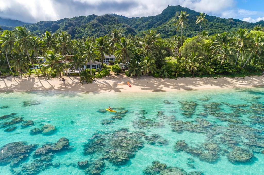 an island with palm trees and a sandy beach at Vaka Beach Cottage with AC Unlimited Wifi in Rarotonga