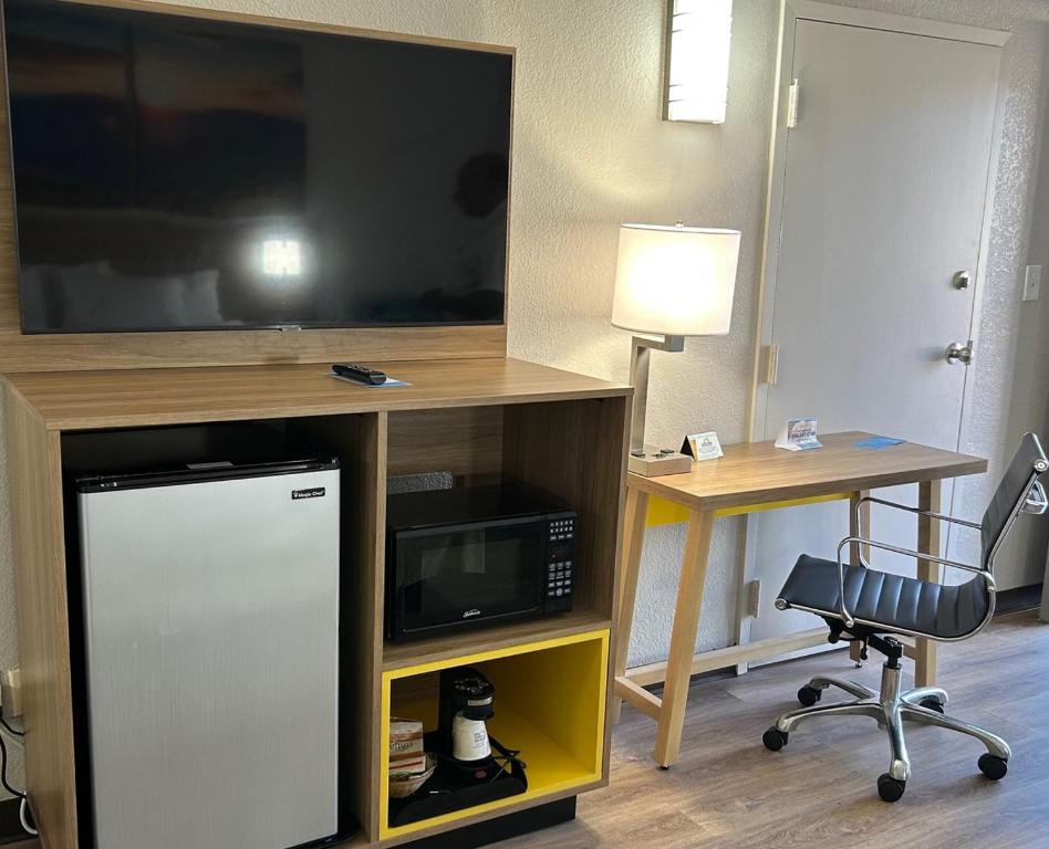 a room with a tv and a desk with a chair at Days Inn by Wyndham Clayton in Clayton