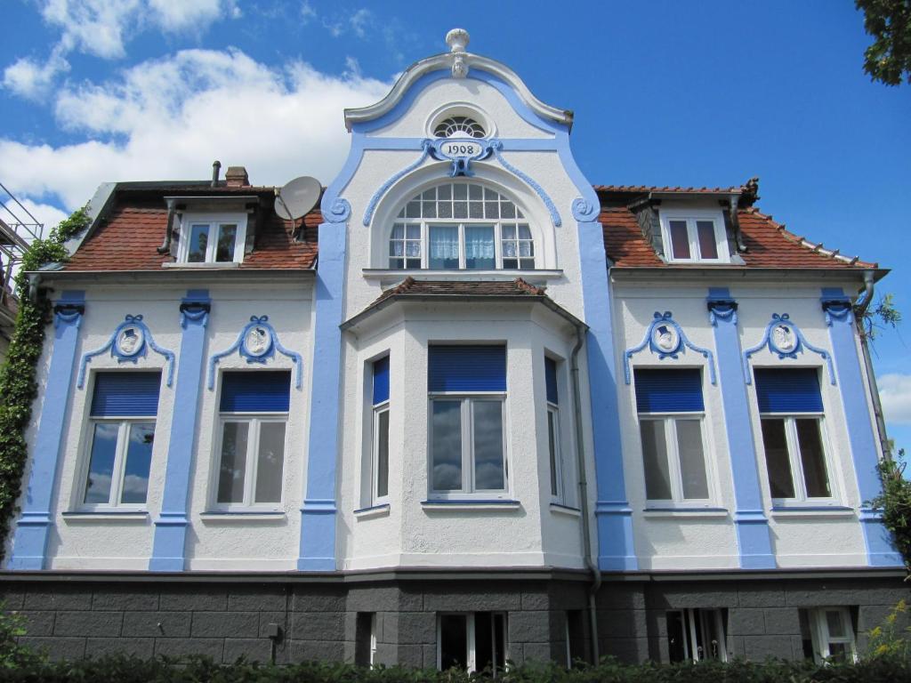 ein blau-weißes Gebäude mit einer Uhr drauf in der Unterkunft Villa Romantica Lenzen in Körbitz