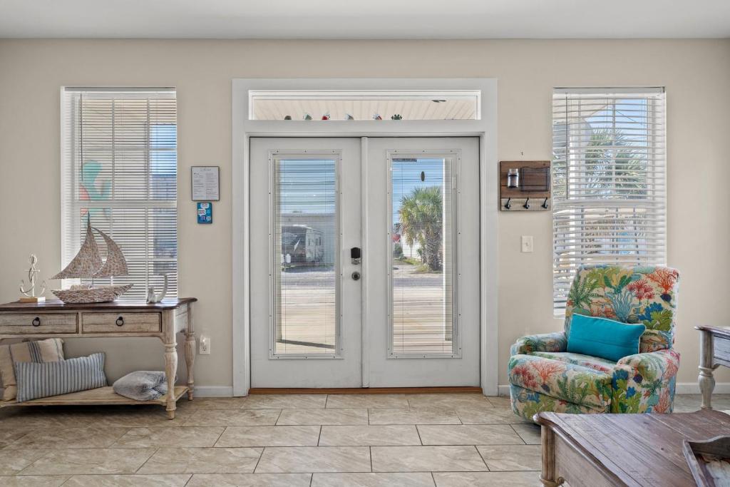 sala de estar con puerta y silla en Blue Oasis Beach Vacation Home with Private Pool & Hot Tub, en Panama City Beach
