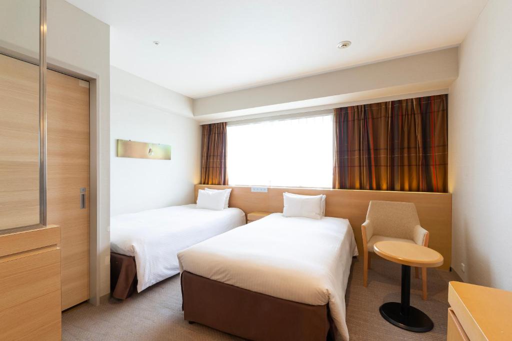 Postel nebo postele na pokoji v ubytování Hotel Keihan Kyobashi Grande