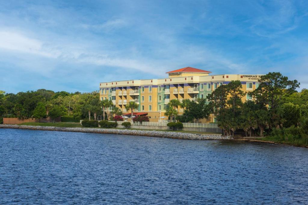 a large yellow building next to a body of water at TownePlace Suites by Marriott Fort Walton Beach-Eglin AFB in Fort Walton Beach