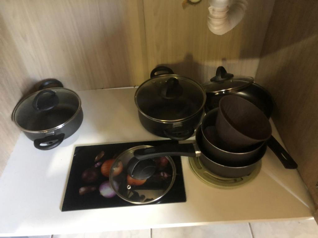 two pots and pans on a counter with a plate of food at Casa da Família Tonial in Gramado
