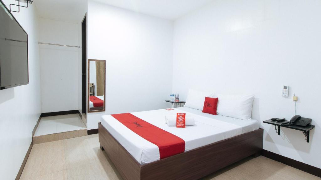 een slaapkamer met een bed met een rode doos erop bij RedDoorz at San Antonio Makati in Manilla