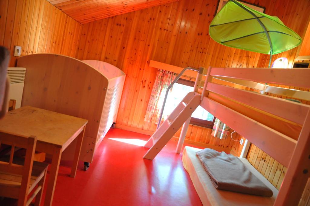 a bunk bed in a cabin with a desk and an umbrella at La Ribambelle in Somme-Leuze