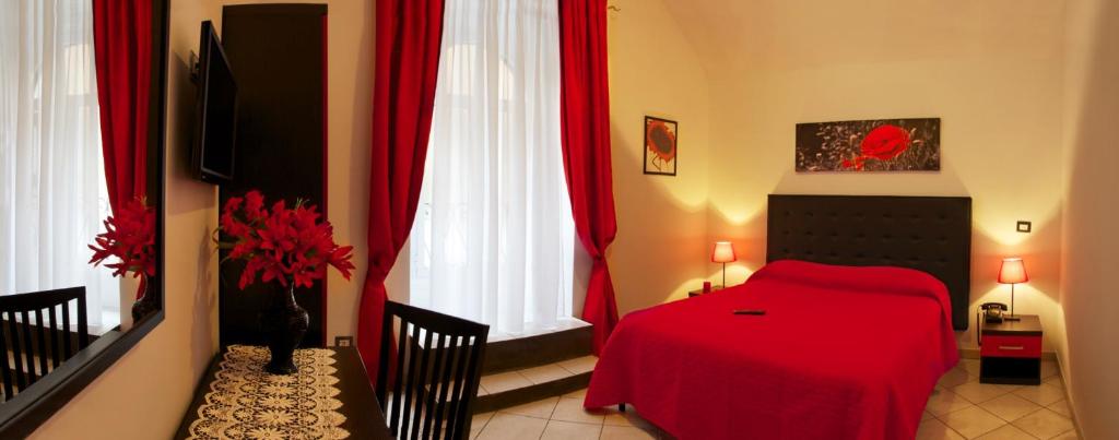 a bedroom with a red bed and red curtains at Termini in Bed in Rome