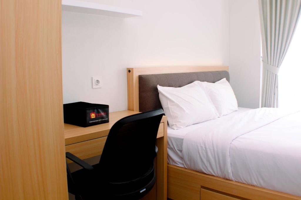 Кровать или кровати в номере Comfort 1BR at Vasanta Innopark Apartment By Travelio