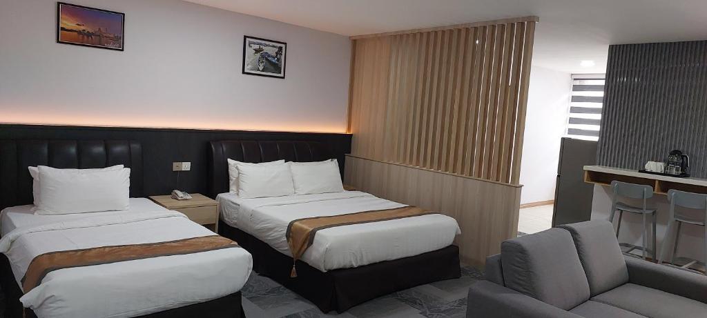 a hotel room with two beds and a chair at Al Afiah Hotel in Bandar Seri Begawan