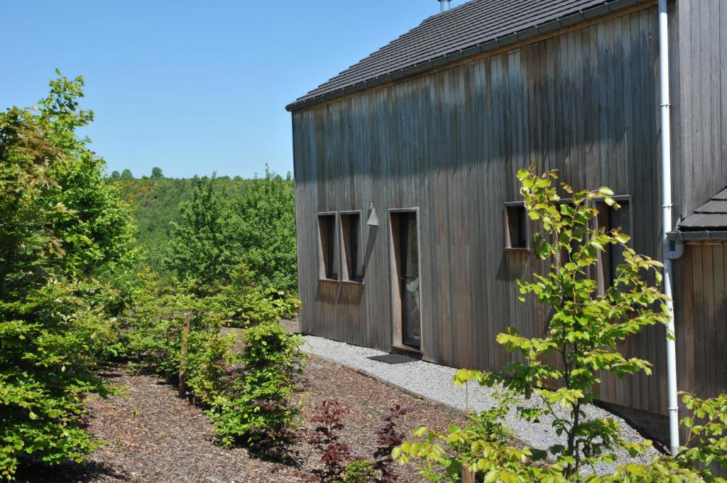 een houten huis met een tuin ervoor bij Jardins de Ourthe 16 in Houffalize