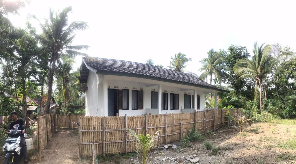a small house with a fence in front of it at Homestay Saptia Dewi in Sengkol