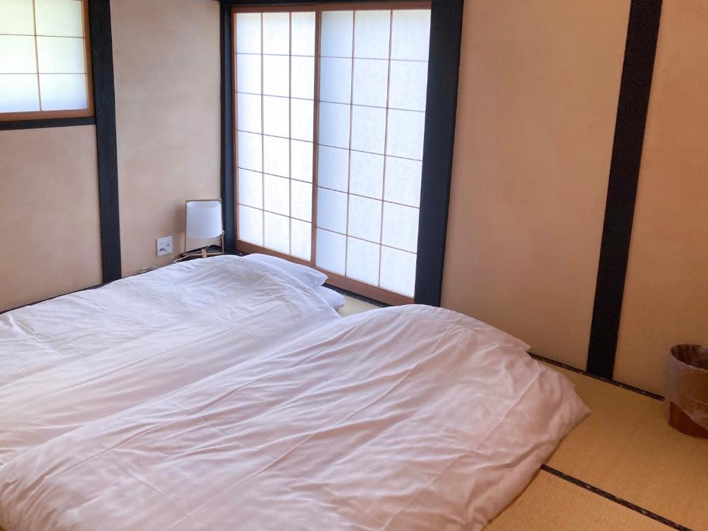 Postel nebo postele na pokoji v ubytování Kabuto Villas ー古民家ステイー