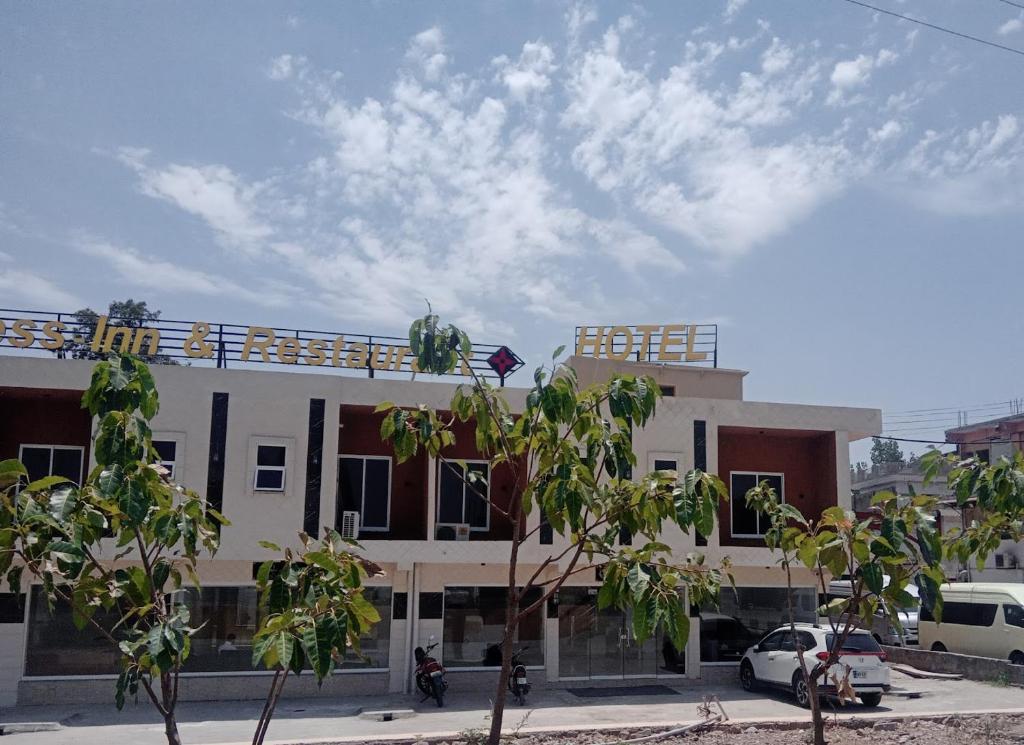 Un edificio blanco con árboles delante. en Bless-Inn & Restaurant, en Islamabad