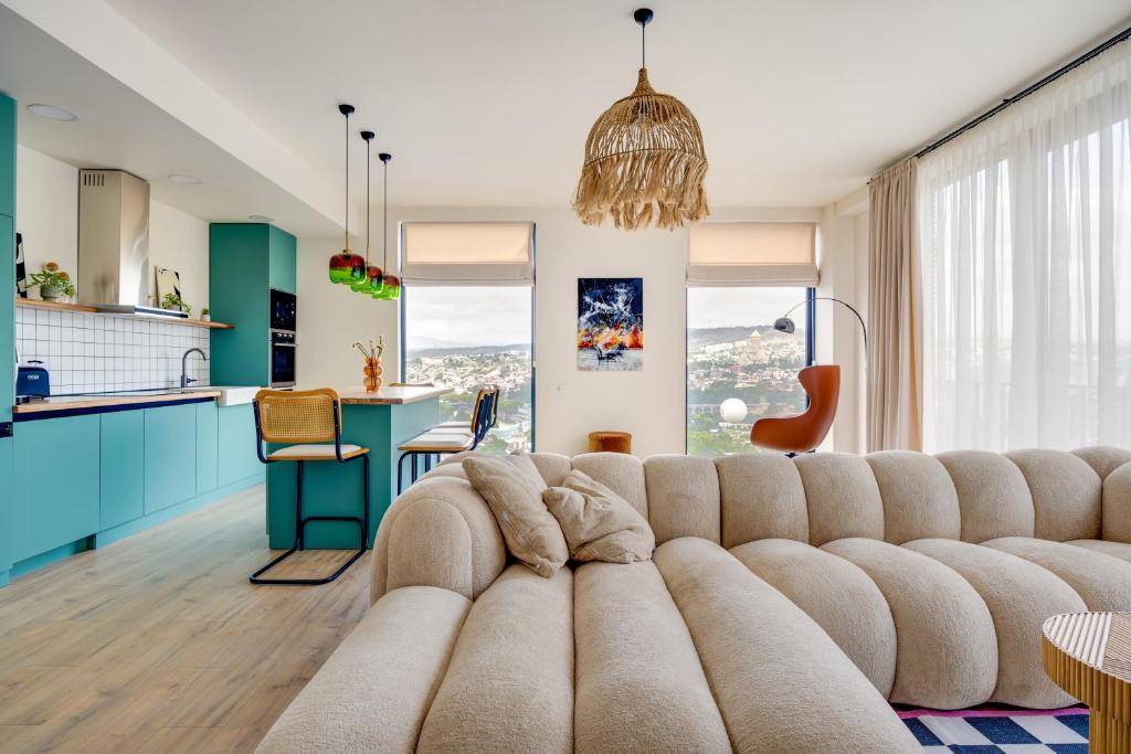 a large couch in a living room with a kitchen at Old Town Panorama View in Tbilisi City