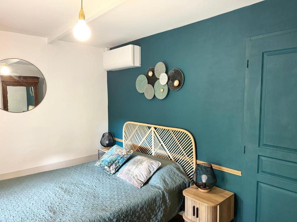 ein Schlafzimmer mit einem Bett und einer blauen Wand in der Unterkunft Villa LEONA CLIM PARK in Bollène