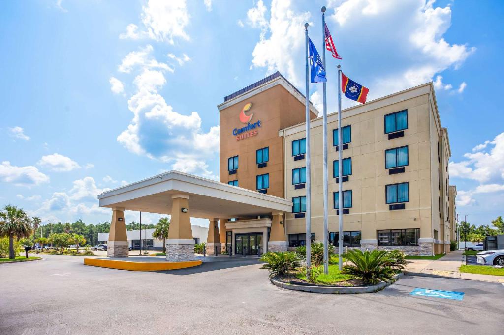 a hotel with two flags in a parking lot at Comfort Suites in Gulfport