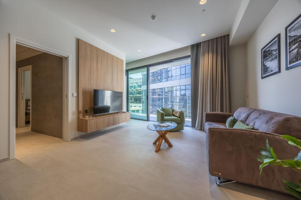 a living room with a couch and a tv at The Signature Suite in Mercury Tower in St. Julianʼs