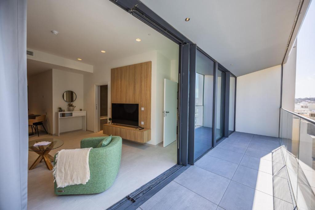 a living room with a couch and a tv at The Signature Suite in Mercury Tower in St. Julianʼs