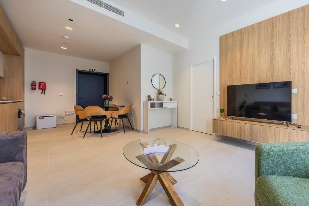 a living room with a tv and a table at The Signature Suite in Mercury Tower in St. Julianʼs