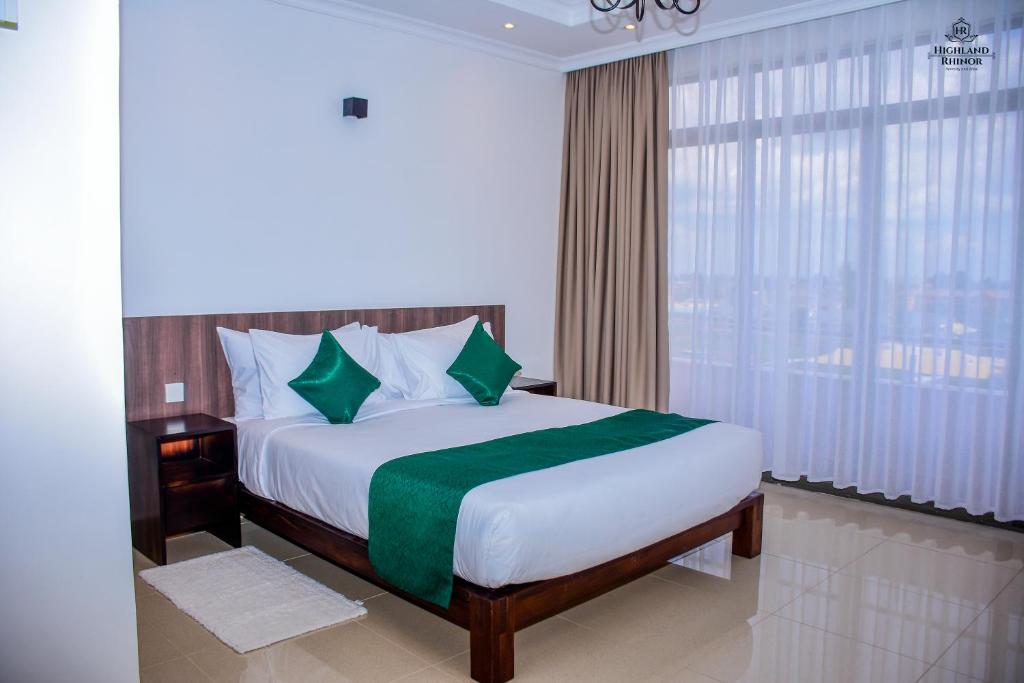 a bedroom with a bed and a large window at Highland Rhinor in Eldoret