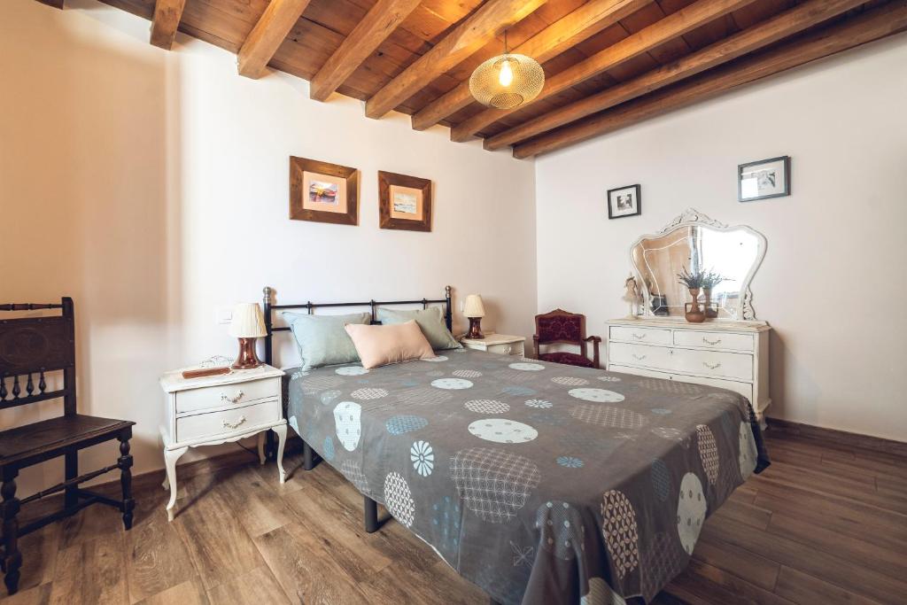 a bedroom with a bed and two dressers and a mirror at CR "El Arrabal" Valle de La Vera in Villanueva de la Vera