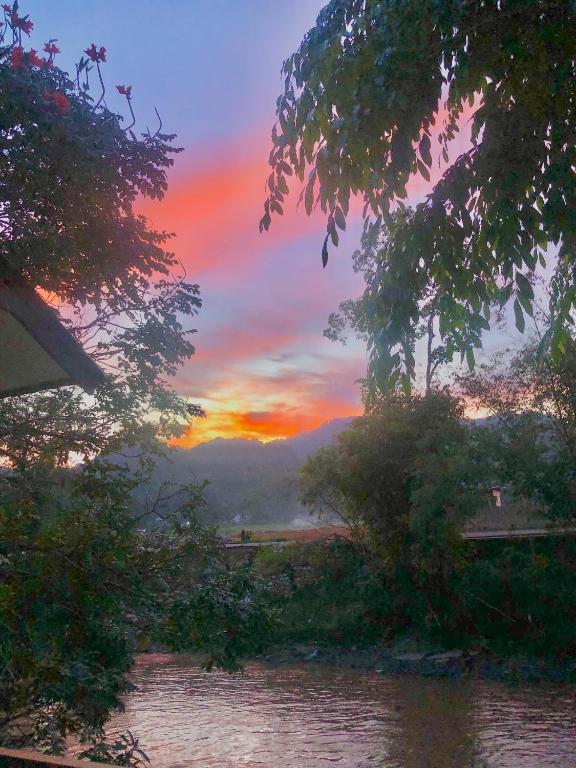 a sunset over a body of water with trees at Pondok Anugerah in Rantepao