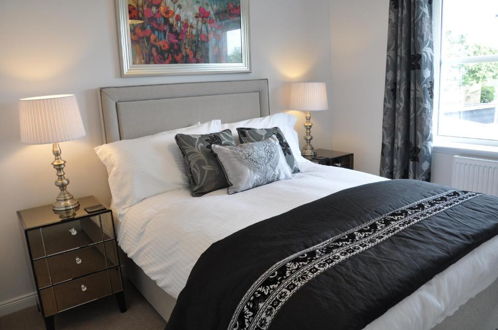 ein Schlafzimmer mit einem großen Bett mit Kissen darauf in der Unterkunft Westgate Apartments Birchlee in Inverurie