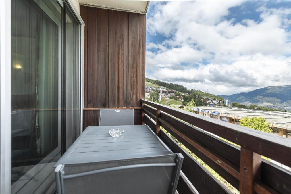 een balkon met een tafel en uitzicht bij Smartstay - Appartement cosy courchevel 1850 in Courchevel