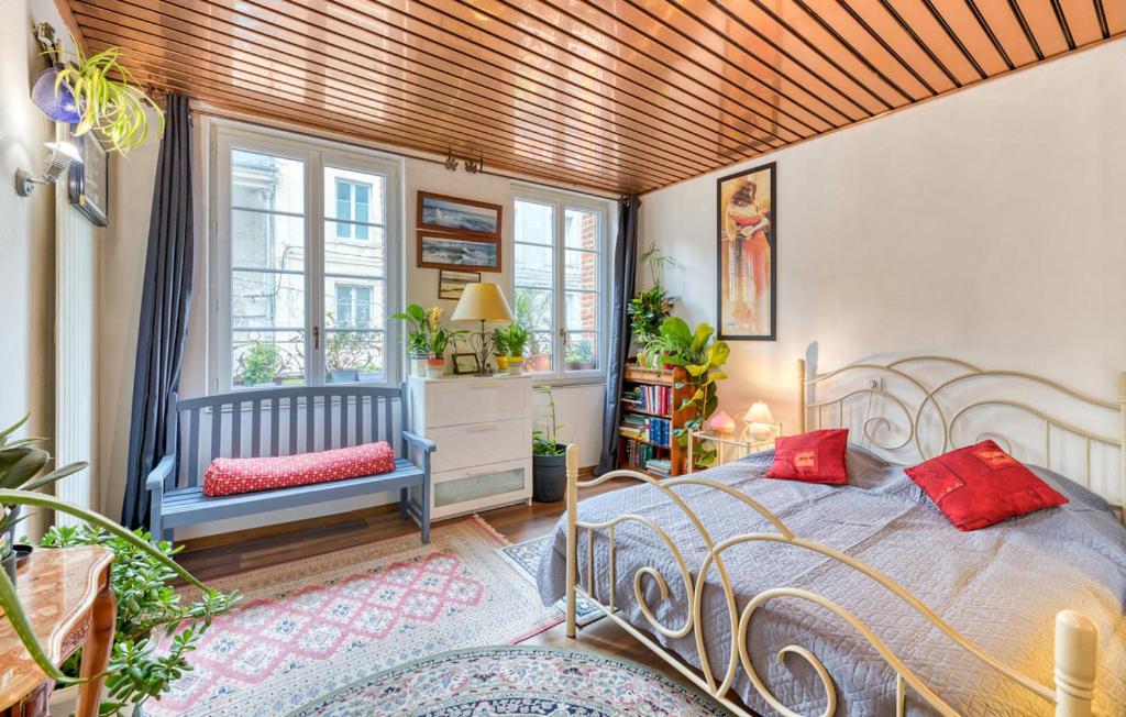 une chambre avec un lit, une chaise et des fenêtres dans l'établissement T1 Centre ville 1500m de la plage 15 km de l'Etretat, à Fécamp