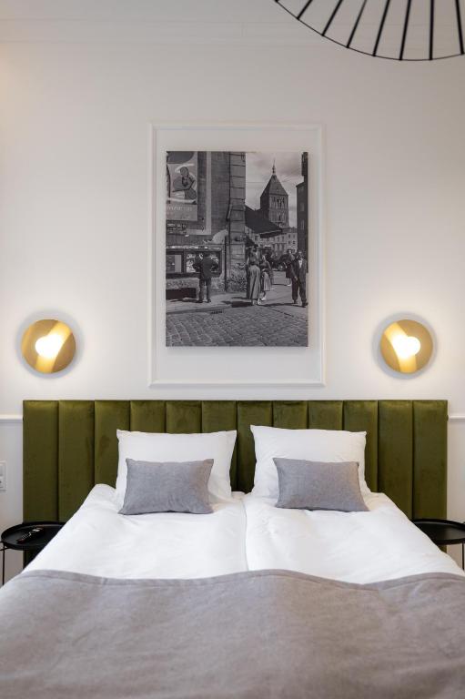 a bedroom with two beds and a picture on the wall at Stara Drukarnia Aparthotel in Koszalin
