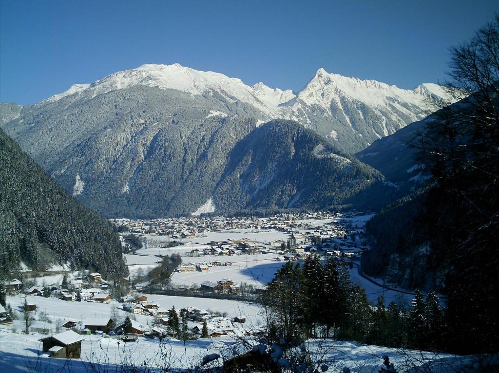a town in a valley with snow covered mountains at Haus Lundegg in Finkenberg
