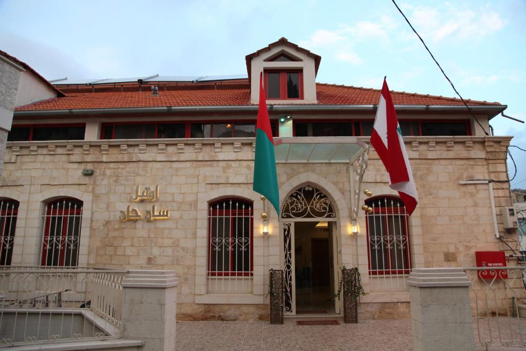 um edifício com duas bandeiras à frente em Hotel St Jean em Zahlé