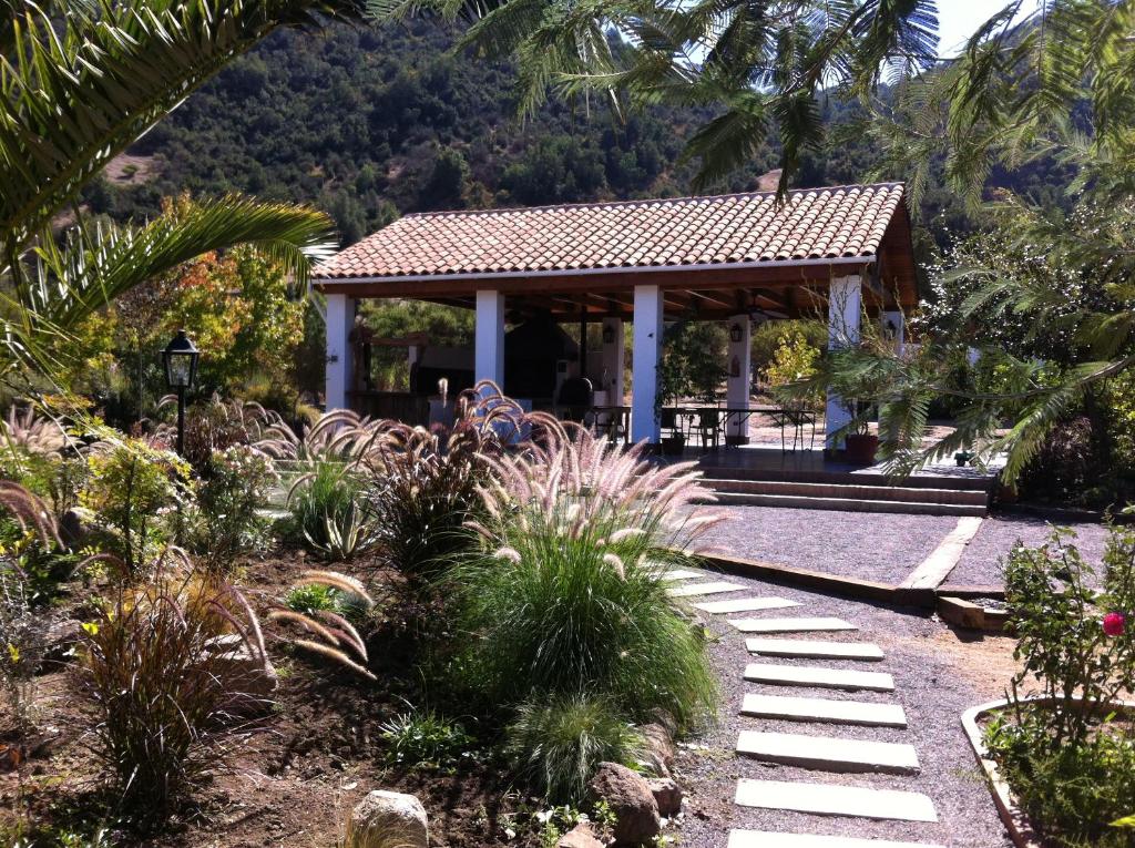 a gazebo in a garden with palm trees at Hotel Boutique Solaz Bella Vista de Colchagua in Santa Cruz
