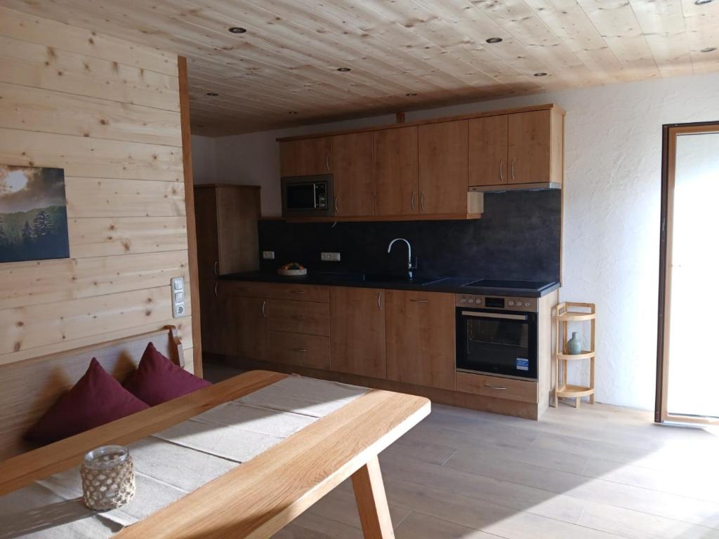 a kitchen with wooden cabinets and a table in a room at Ferienwohnungen Tauernalm in Heiligenblut