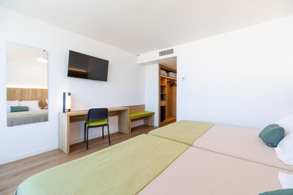 a white room with a bed and a desk at Ohtels Carabela in Matalascañas