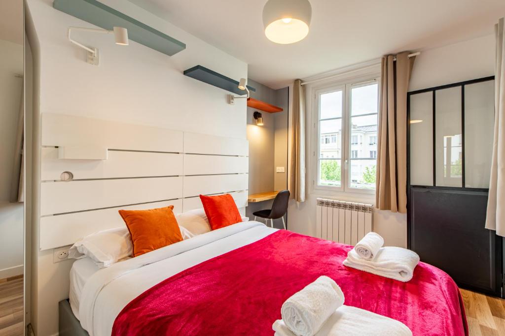 une chambre avec un grand lit avec une couverture rouge dans l'établissement Cozy 1-bedroom apartment with all amenities near iconic Montmartre neighbourhood, à Paris