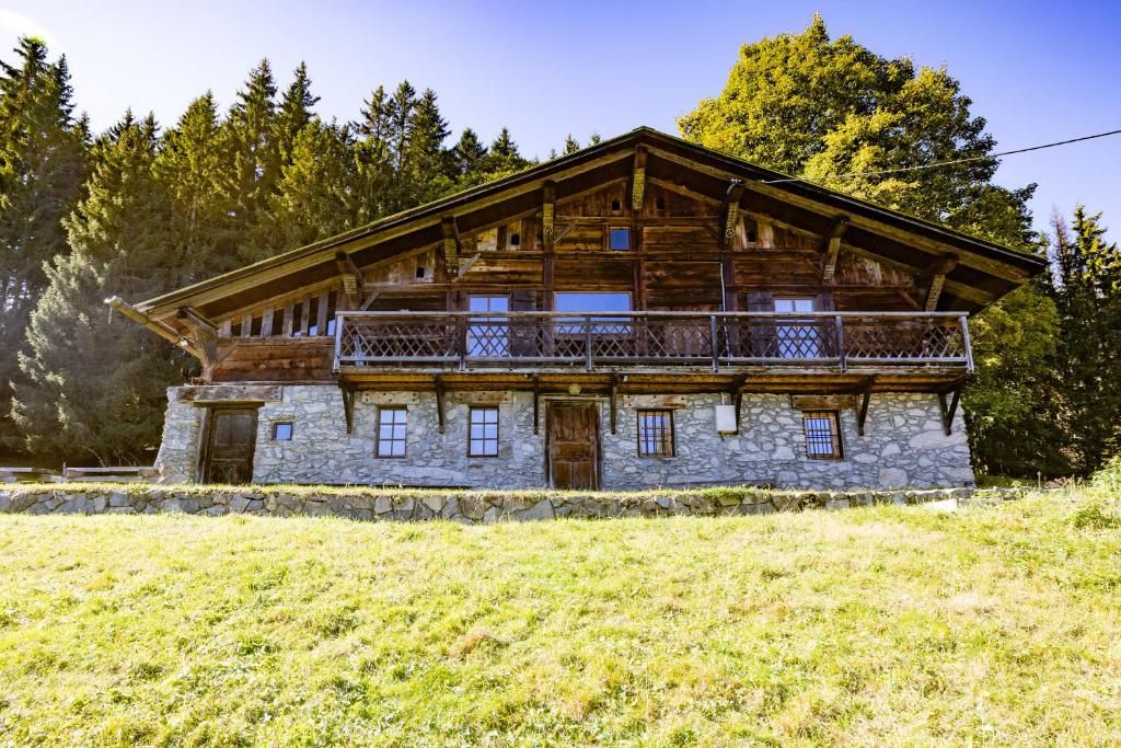 Cette maison en rondins dispose d'un balcon au sommet d'une colline. dans l'établissement Chalet d'alpage Cornillon, à Cordon