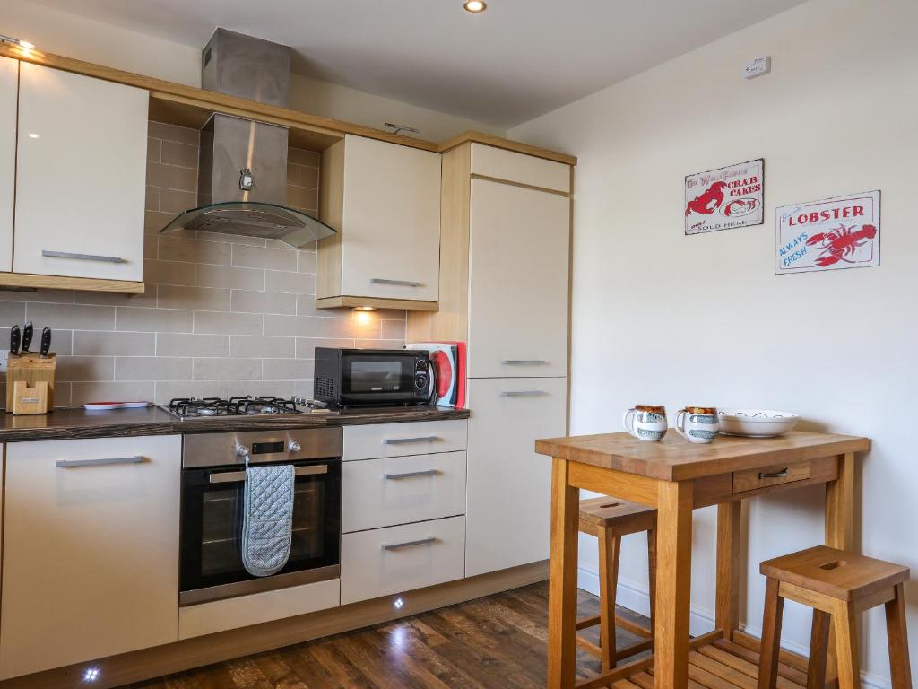 a kitchen with a stove and a microwave at Tides Reach in Rhosneigr