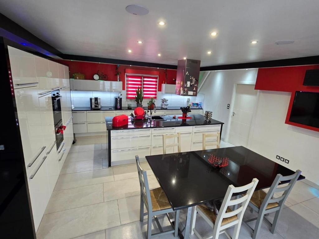 a large kitchen with a black table and chairs at Bretzel Home in Colmar