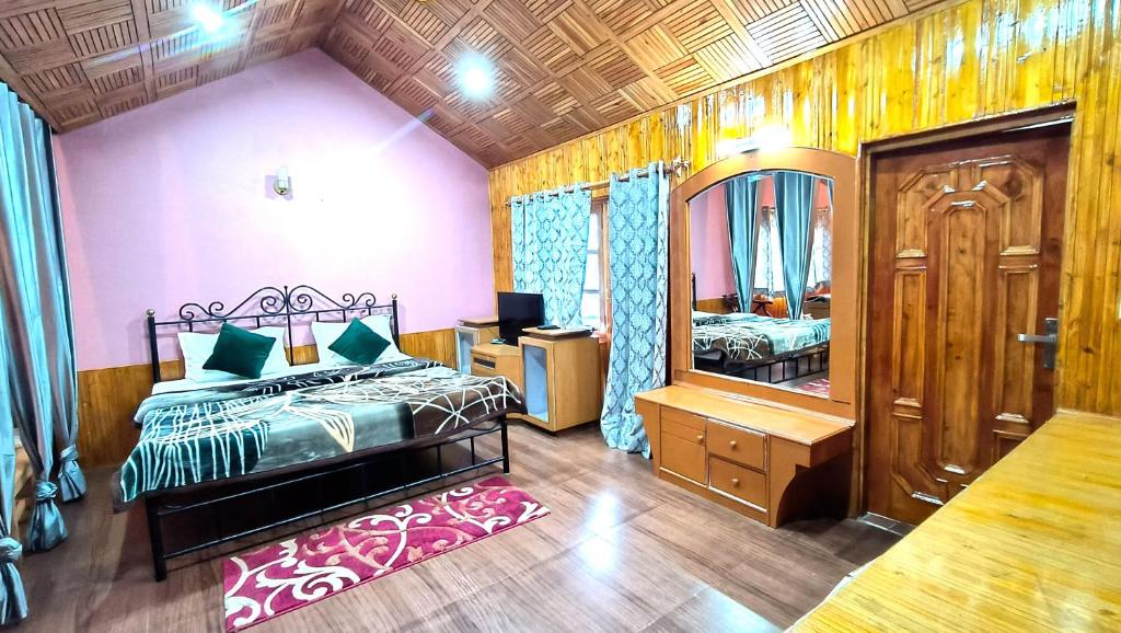 un dormitorio con una cama y un espejo en Melody Orchard Cottage, en Jagatsukh