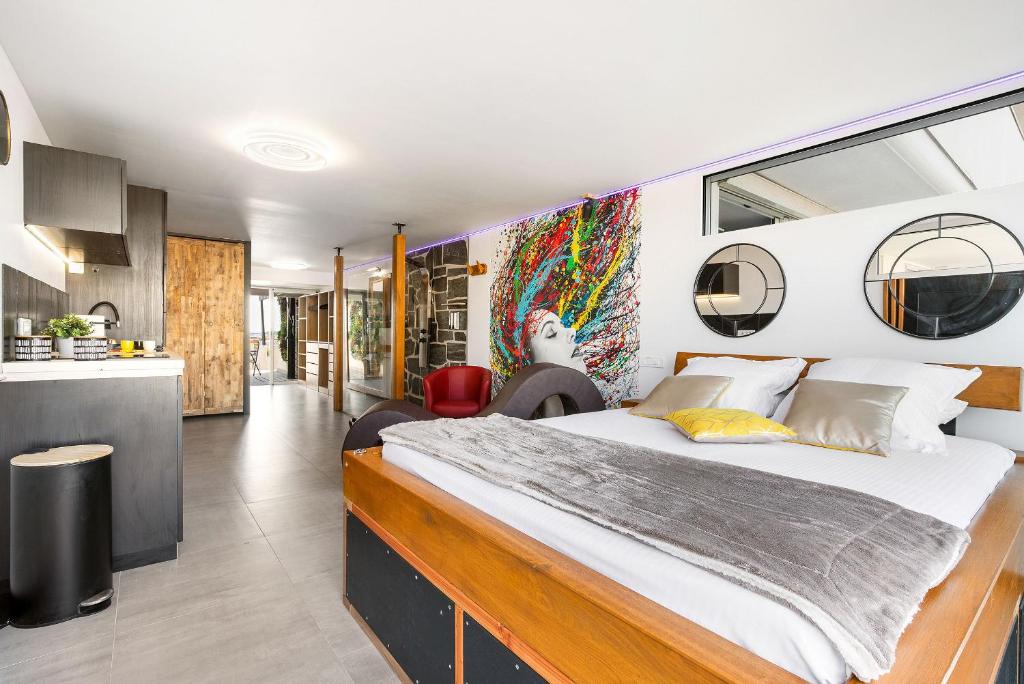 une chambre avec un grand lit et une cuisine dans l'établissement Village Naturiste R4N - Atypique Port Nature 1, au Cap d'Agde