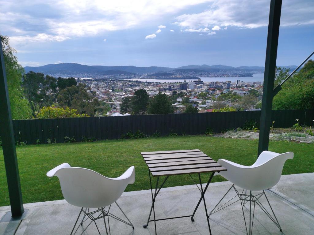 una mesa y 2 sillas en un patio con vistas en Hobart Retreat with City and Water View, en West Hobart